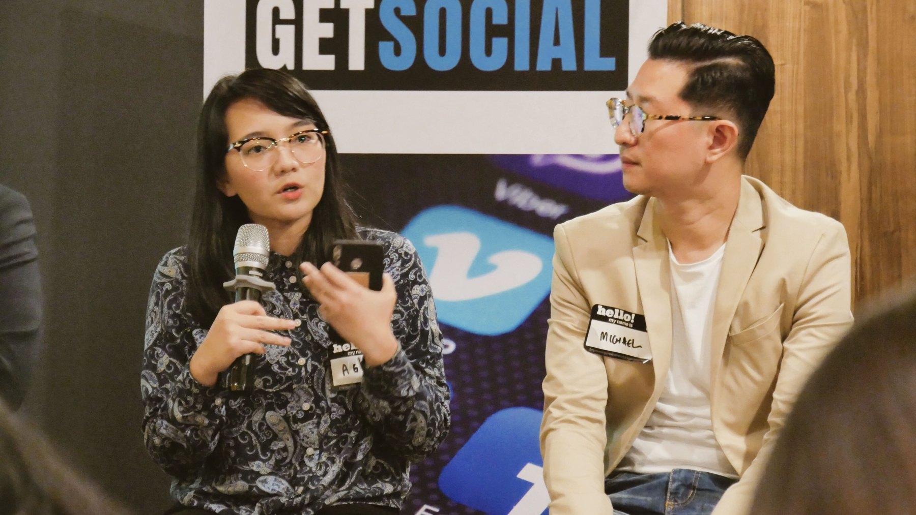 Agni speaking into a microphone during a GetSocial panel conversation